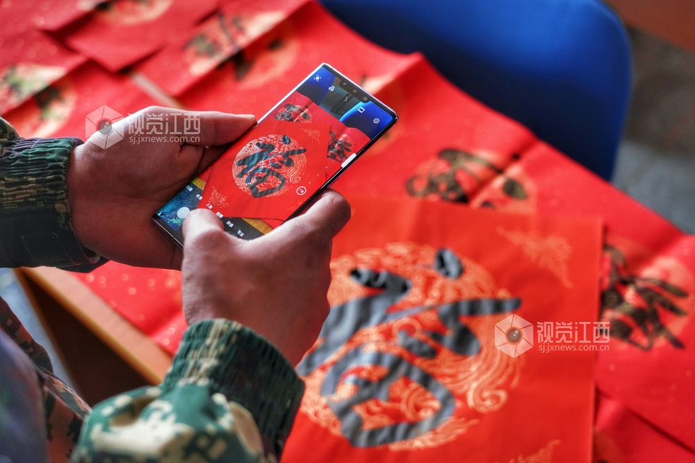 活动现场，书法家们在长桌上铺开红纸，挥毫泼墨，为官兵们写春联，送“福”字，提前送上新春的祝福。